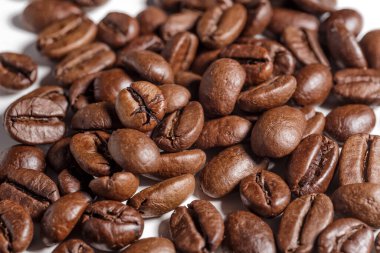 Taze kavrulmuş kahve çekirdekleri. Ahşap arka planda kepçeyle kavrulmuş kahve çekirdekleri..