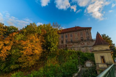 Roudnice Nad Labem kasabasında eski kilisesi ve Labe nehri kuleleri olan turuncu gün batımı.