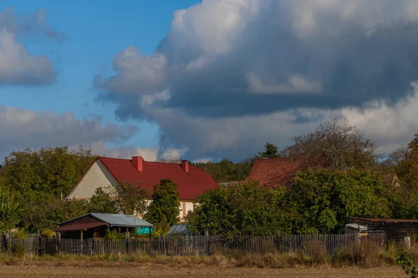 秋の色の日に青い空と雲と赤い屋根の古い村の建物 — ストック写真