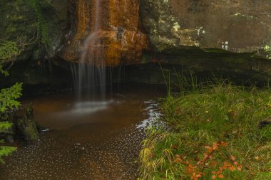 Kuzey Çek Cumhuriyeti 'nde sonbahar yağmurlu sabahında Jedlova istasyonu yakınlarında Bukovy şelalesi
