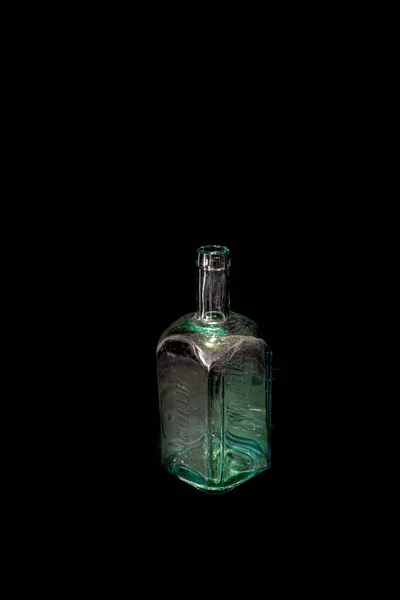 新鮮な光と黒の背景を持つ古い色汚れたガラス瓶 — ストック写真
