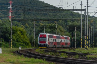 Yaz bulutlu akşamında kırmızı elektrikli tren.