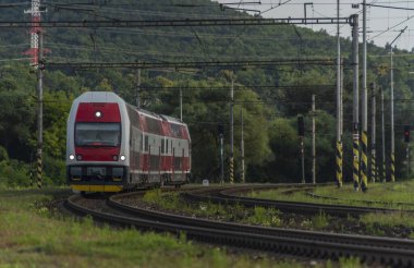 Yaz bulutlu akşamında kırmızı elektrikli tren.