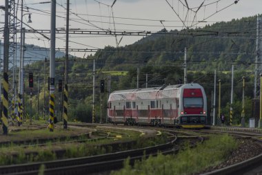 Yaz bulutlu akşamında kırmızı elektrikli tren.