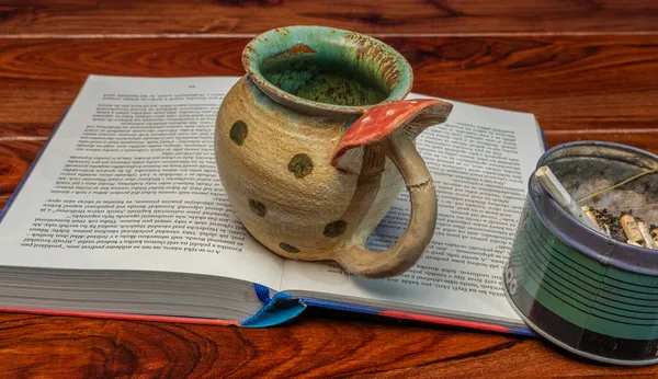 棕色木制桌子上的蘑菇茶 上面有书和烟灰缸 — 图库照片