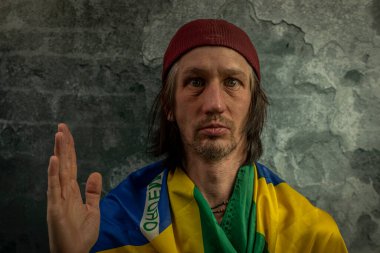 Sakallı adam portresi, eski renkli taş duvarın yanında.