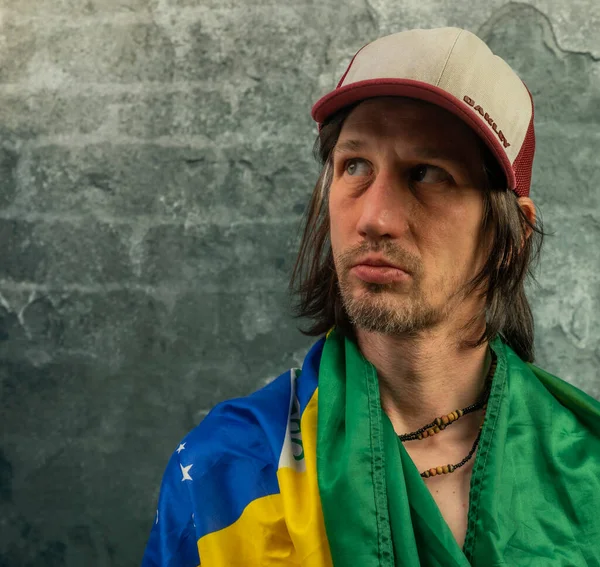 Sakallı adam portresi, eski renkli taş duvarın yanında.