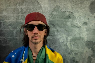 Sakallı adam portresi, eski renkli taş duvarın yanında.