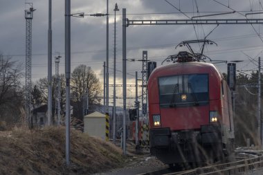 Kırmızı yolcu Avusturya Velesin İstasyonu 'nda kış günü soğuk bir günde tren çalışır.