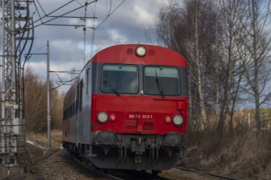 Kırmızı yolcu Avusturya Velesin İstasyonu 'nda kış günü soğuk bir günde tren çalışır.
