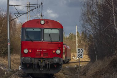 Kırmızı yolcu Avusturya Velesin İstasyonu 'nda kış günü soğuk bir günde tren çalışır.