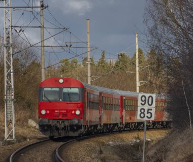 Kırmızı yolcu Avusturya Velesin İstasyonu 'nda kış günü soğuk bir günde tren çalışır.