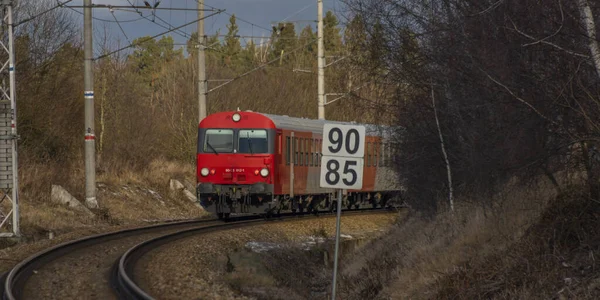 Kırmızı yolcu Avusturya Velesin İstasyonu 'nda kış günü soğuk bir günde tren çalışır.