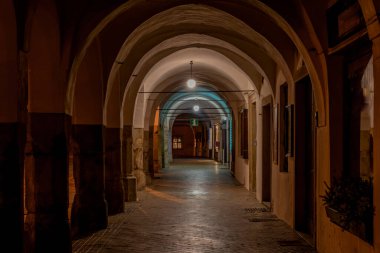 Telc kasabası kışın karanlık gecesinde turuncu sokak lambaları ve eski loggiasıyla