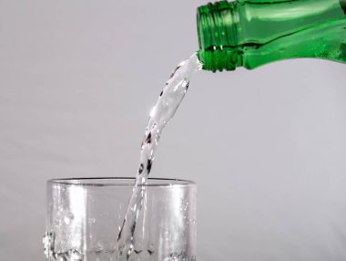 Akan temiz suyu ve gri koyu arkaplanı olan cam.