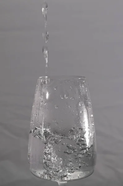 Glas Med Rinnande Rent Vatten Och Grå Mörk Bakgrund — Stockfoto