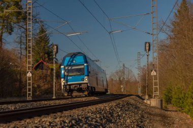 Güneşli kış gününde Senohraby İstasyonu yakınlarındaki hızlı yolcu treni.
