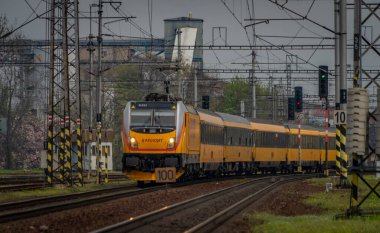 Ostrava kenti yakınlarındaki trenler ilkbaharda taze renk bulutlu bir günde
