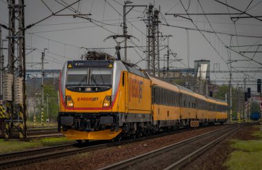 Ostrava kenti yakınlarındaki trenler ilkbaharda taze renk bulutlu bir günde