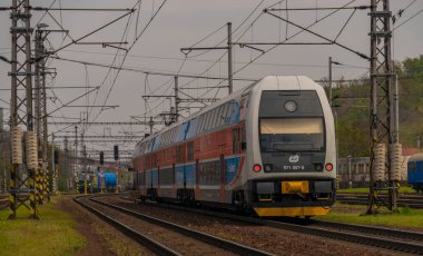 Ostrava kenti yakınlarındaki trenler ilkbaharda taze renk bulutlu bir günde