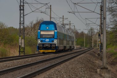 Ostrava kenti yakınlarındaki trenler ilkbaharda taze renk bulutlu bir günde
