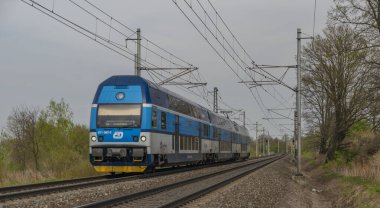 Ostrava kenti yakınlarındaki trenler ilkbaharda taze renk bulutlu bir günde