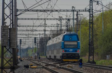 Ostrava kenti yakınlarındaki trenler ilkbaharda taze renk bulutlu bir günde