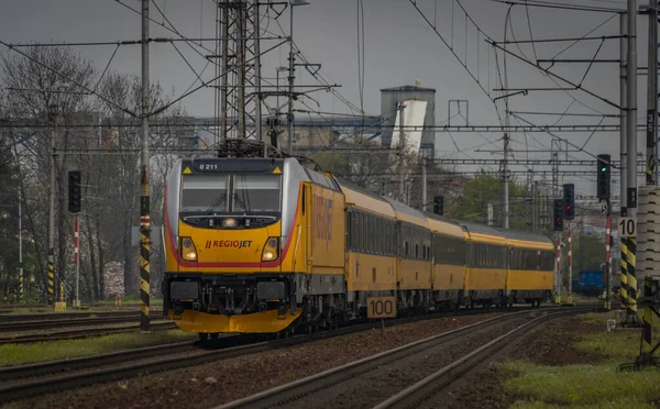 Ostrava kenti yakınlarındaki trenler ilkbaharda taze renk bulutlu bir günde