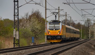 Ostrava kenti yakınlarındaki trenler ilkbaharda taze renk bulutlu bir günde