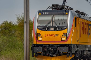 Ostrava kenti yakınlarındaki trenler ilkbaharda taze renk bulutlu bir günde