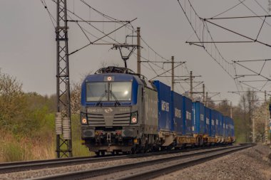 Ostrava kenti yakınlarındaki trenler ilkbaharda taze renk bulutlu bir günde