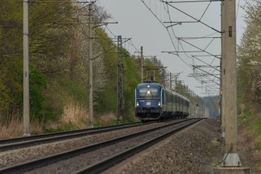 Ostrava kenti yakınlarındaki trenler ilkbaharda taze renk bulutlu bir günde