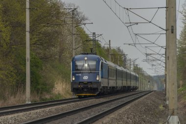 Ostrava kenti yakınlarındaki trenler ilkbaharda taze renk bulutlu bir günde