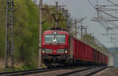 Ostrava kenti yakınlarındaki trenler ilkbaharda taze renk bulutlu bir günde