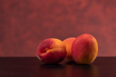 Siyah masada kırmızı arka planda taze kayısılar