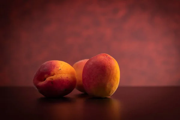 Albicocche Colore Fresco Tavolo Nero Con Sfondo Rosso — Foto Stock