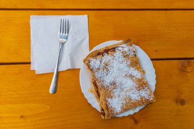 Velika Planina 'da yaz mevsimi taze doğasında elmalı, tarçınlı ve yeni ahşap masa üzerinde şekerli çörek.
