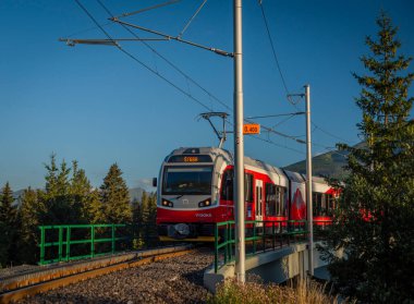 Trains in Strba station under Vysoke Tatry mountains in summer morning