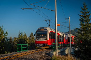 Trains in Strba station under Vysoke Tatry mountains in summer morning