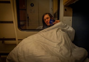Man before sleeping in compartment of sleeping coach from Prague to Slovakia in summer night