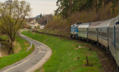Moravya 'daki Jihlava kasabası yakınlarında mavi dizel lokomotif ve mavi yolcu vagonu.