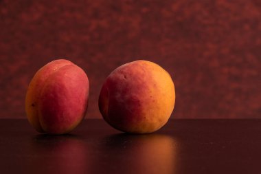 Siyah masada kırmızı arka planda taze kayısılar