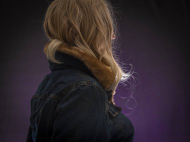 Sarı saçlı, menekşe rengi arka planda bir kadın.