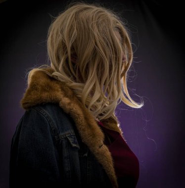 Sarı saçlı, menekşe rengi arka planda bir kadın.