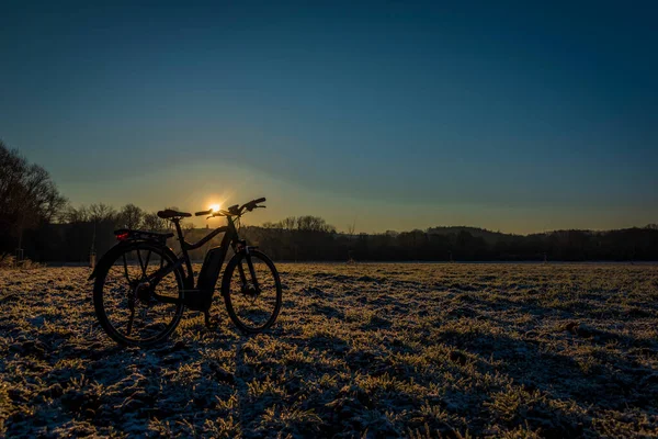 Czarno Szary Rower Elektryczny Wschodzie Słońca Poranek Mroźnym Polu Żółtym — Zdjęcie stockowe