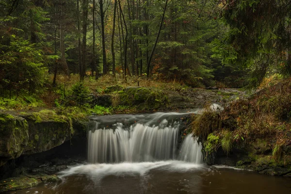 Hamersky creek with waterfalls in Luzicke mountains in color autumn rainy day