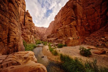 Wadi Mujib Biyosfer Rezervi, nehirli kırmızı kaya vadisi. Mavi gökyüzü olan Ürdün su akıntısı. Wadi Mujib en düşük doğa koruma alanı, Ölü Deniz yakınlarındaki muhteşem manzara dizisi.