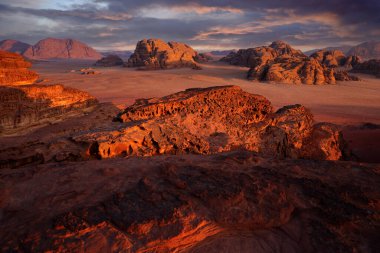 Ürdün 'e seyahat, Arabistan doğası. Wadi Rum Çölü, taşlı ve taşlı kırmızı sedan. Akşam turuncu gün batımı doğada.