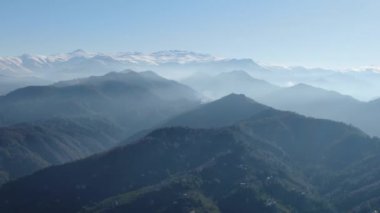 Türkiye 'nin kuzeyindeki Trabzon' da yağmur mevsiminde yemyeşil yağmur bulutları içindeki bir köyün havadan görünüşü yağmur ormanları dağını örtüyor    