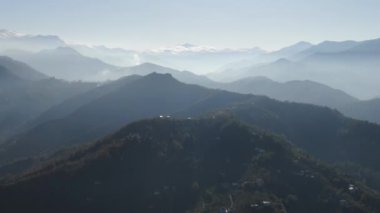 Türkiye 'nin kuzeyindeki Trabzon' da yağmur mevsiminde yemyeşil yağmur bulutları içindeki bir köyün havadan görünüşü yağmur ormanları dağını örtüyor    
